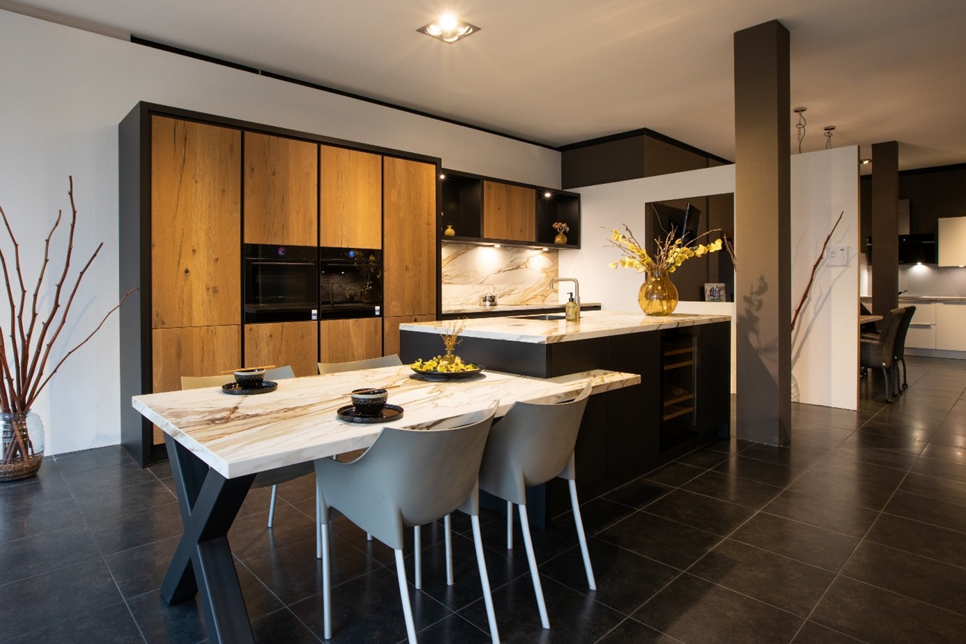 keuken met kookeiland en aansluitend keukenblad met stoelen